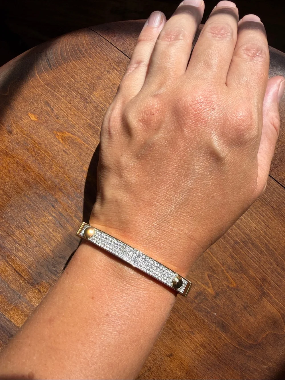 Michael Kors gold-tone hinge bangle featuring a center row of pave-set crystals